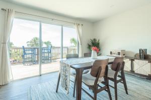 Un comedor con mesa y sillas y un balcón. en Seafarer Beach Resort - Ocean View with a Pool on the Beach, en Englewood
