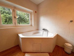 una bañera en un baño con ventana en Maison familiale climatisée, jardin cinema et jeux, en Épisy 28 fotos más
