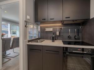 a kitchen with a sink and a stove at Hotel Strandhörn in Wenningstedt