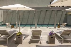 una piscina con sedie e un ombrellone di Polanco condo, alberca y Gym a Città del Messico