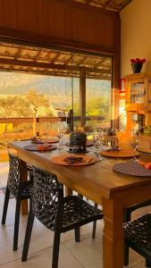 a kitchen with a wooden table with wine glasses at Casa Varanda do Toá Lapinha da Serra in Santana do Riacho