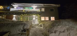 a house with christmas lights on it in the snow at Ramfjord Apartment 2 in Tromsø +1 photo