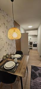 una mesa de comedor con platos y una luz en Ramfjord Apartment 2, en Tromsø