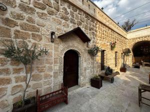 a stone building with a large door and a courtyard at ŞAHMERAN OTEL & Cafe in Midyat +46 photos