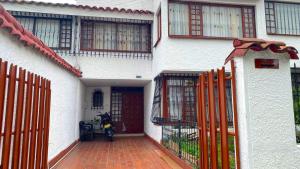 a motorcycle parked in front of a house with a fence at Villa Santa Ines in Bogotá