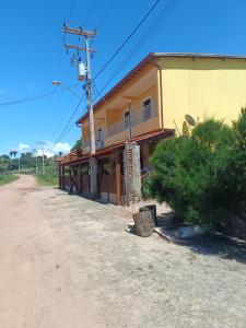 una casa gialla sul lato di una strada sterrata di Maria do Bairro a Guaraciaba do Norte