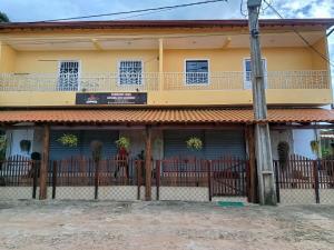 a yellow house with a fence in front of it at Maria do Bairro in Guaraciaba do Norte