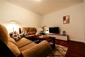 a living room with a couch and a tv at Casa Verde Logroño in Logroño