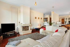 ein Wohnzimmer mit einem weißen Sofa und einem Fernseher in der Unterkunft traveller's house in Machico