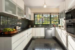 eine Küche mit weißen Schränken und einer Obstschale auf der Theke in der Unterkunft traveller's house in Machico