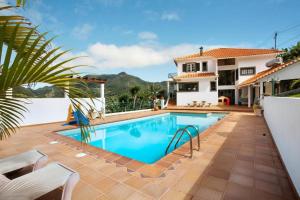 ein Swimmingpool vor einem Haus in der Unterkunft traveller's house in Machico