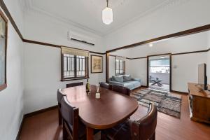 Comfortable 2 bedroom cottage في بريزبين: غرفة طعام مع طاولة وكراسي +صورة واحدة