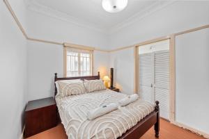 Comfortable 2 bedroom cottage في بريزبين: غرفة نوم بسرير كبير في غرفة مع نافذة