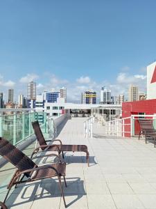 un gruppo di sedie seduti su un tetto di Apartamento na praia de Manaíra João Pessoa PB a João Pessoa