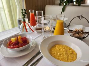 ein Tisch mit einer Schüssel Müsli und einer Schale Obst in der Unterkunft Hôtel et Restaurant Les2M in Fontenay-le-Comte