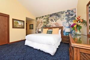 a bedroom with a large bed and a floral wallpaper at Kaanapali Royal D302 · KRL D302 Updated Kaanapali 2BD on Golf Co in Lahaina +44 photos