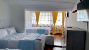 a small bedroom with two beds and a dresser at Villa Santa Ines in Bogotá