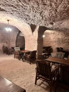 a dining room with tables and chairs in a cave at ŞAHMERAN OTEL & Cafe in Midyat
