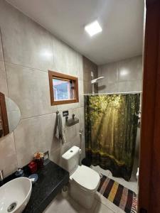 a bathroom with a toilet and a shower curtain at Casa Varanda do Toá Lapinha da Serra in Santana do Riacho