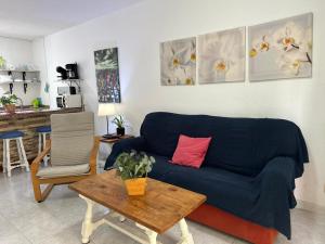een woonkamer met een blauwe bank en een tafel bij Puerto Rico Sea & Sun in Puerto Rico de Gran Canaria
