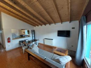 a living room with a couch and a tv at Nomade bedbox Hostel in El Chalten