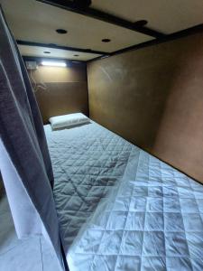 an empty bed in a small room with a mattress at Nomade bedbox Hostel in El Chalten