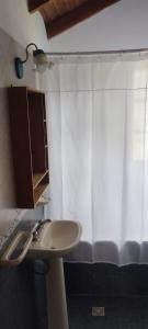 a bathroom with a sink and a shower curtain at Las Rosas EH in El Hoyo +36 photos