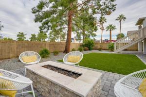 a patio with white chairs and a fire pit at 2 Mi to Dtwn Gorgeous Gilbert Gem with Private Yard in Gilbert