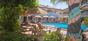 a resort with a pool and people sitting at tables at Cape Point Hotel in Bakau