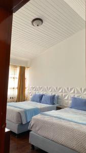 a bedroom with two beds and a ceiling at Villa Santa Ines in Bogotá +6 photos