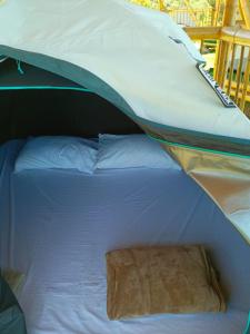 San LuisConexión naturaleza的帐篷里有一张白色床，上面放着一个枕头。