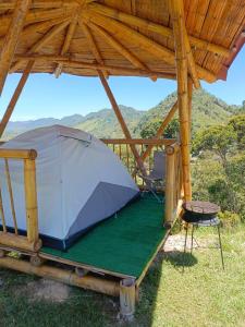 San LuisConexión naturaleza的木屋下有一顶帐篷和一把椅子 更多15张照片