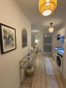 Clichy-sous-BoisStudio haut standing confort et modernité的厨房以及带桌子和洗衣机的客厅。