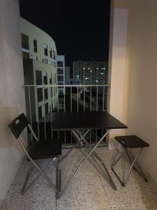 Clichy-sous-BoisStudio haut standing confort et modernité的有窗户的房间里有一张桌子和两把椅子