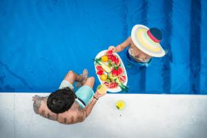a man in a swimming pool holding a bouquet of flowers at NEW!The HideawayPoolPickleballPutt-PuttKayaks! in Marathon +90 photos