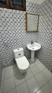 een badkamer met toilet en wastafel bij Кокосовый домик in Nungwi +2 foto's