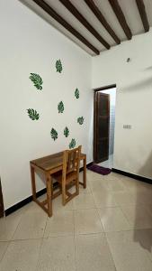 een kamer met een tafel en een bank aan een muur bij Кокосовый домик in Nungwi