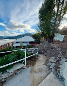 a white fence in front of a garden with a building at Classic, Cozy House for Transient in Baguio City 1 in Baguio