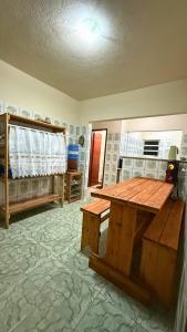 Cette chambre comprend une table en bois. dans l'établissement Hostel Ninho das Harpias, à Divino de São Lourenço