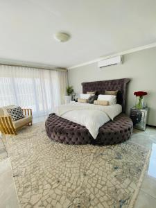a large bedroom with a large bed with a large ottoman at ALIMU villa Mbombela in Nelspruit