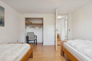 a bedroom with two beds and a chair in it at Calm Holiday Home With Great Outings in Kollund