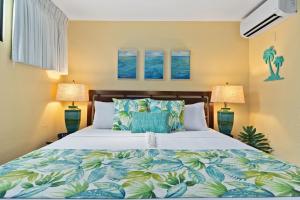 ein Schlafzimmer mit einem großen Bett mit zwei Lampen in der Unterkunft Papakea L101 · PK L101 Maui Ground-Floor Condo with Ocean Views in Honokowai + 50 Fotos