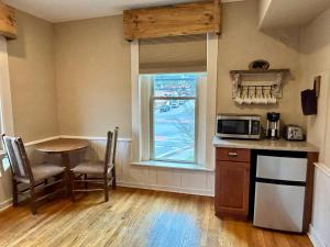 a kitchen with a table and a microwave and a window at Cozy Cub Den, Chic Downtown Loft, Walk to Shops, Train, Restaurants in Bryson City