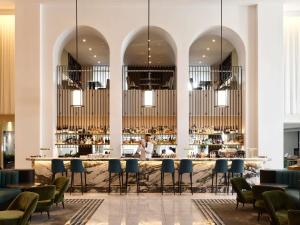 a restaurant with a bar with blue chairs at Swissotel Sydney in Sydney
