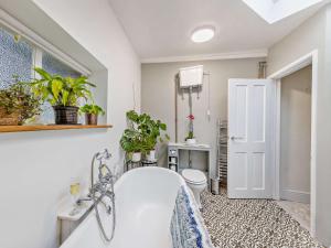 a bathroom with a tub and a toilet and plants at 2 Bed in Brecon 92729 in Brecon +70 photos