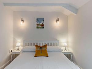 a bedroom with a white bed with a bow pillow on it at 2 Bed in Brecon 92729 in Brecon