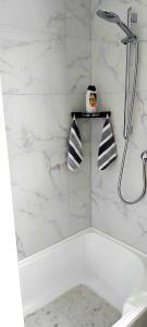 Un baño blanco con ducha y bañera. en Darwin Cottage, en Kerikeri