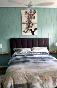 Una cama en un dormitorio con paredes verdes. en Darwin Cottage, en Kerikeri