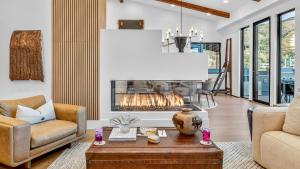 a living room with a fireplace and a table at Crescendo Crest in Steamboat Springs