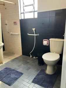a bathroom with a toilet and a shower with blue tiles at Quarto aconchegante no centro in São Luís +14 photos